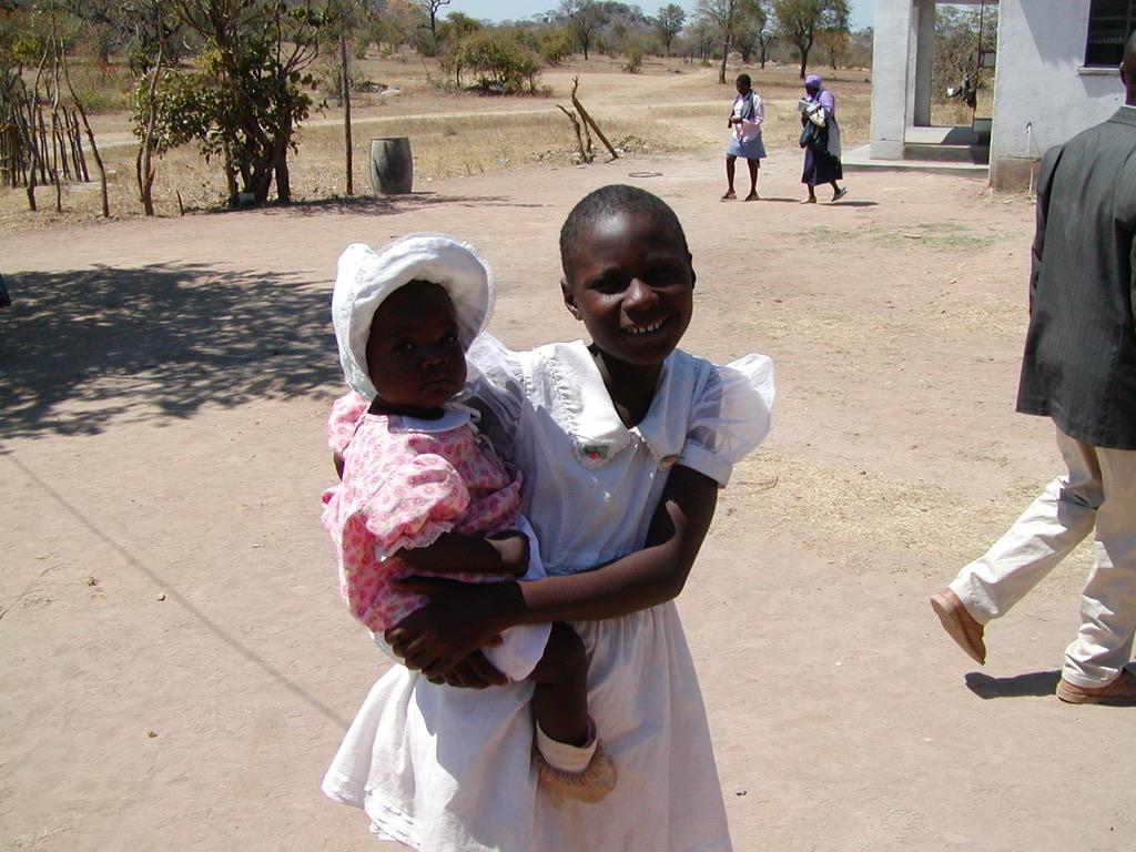 A young girl holding a baby in the Mizizi community, Uganda